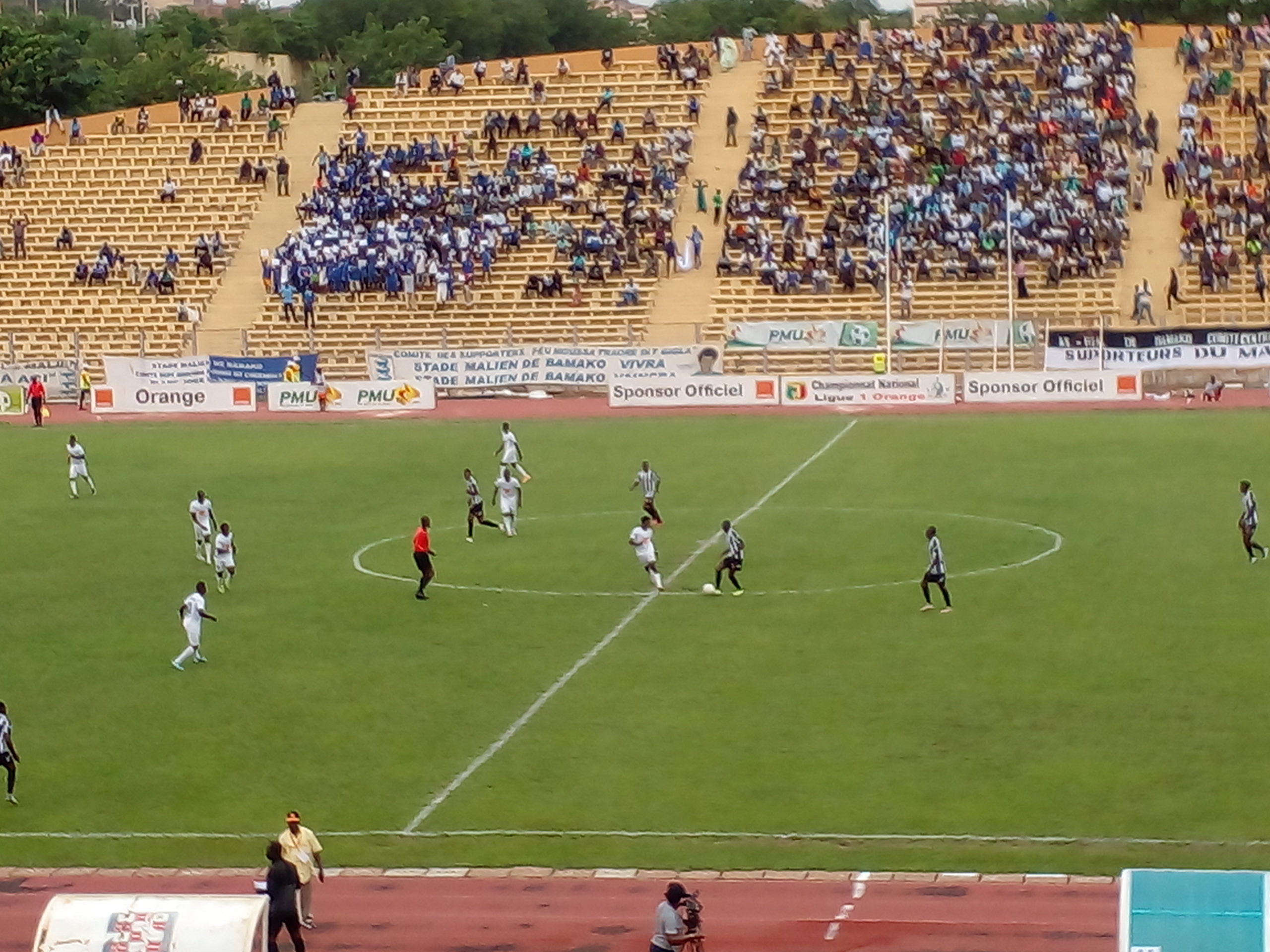  A football match at the Stade Malien in Bamako, Mali, with a large crowd in the stands.